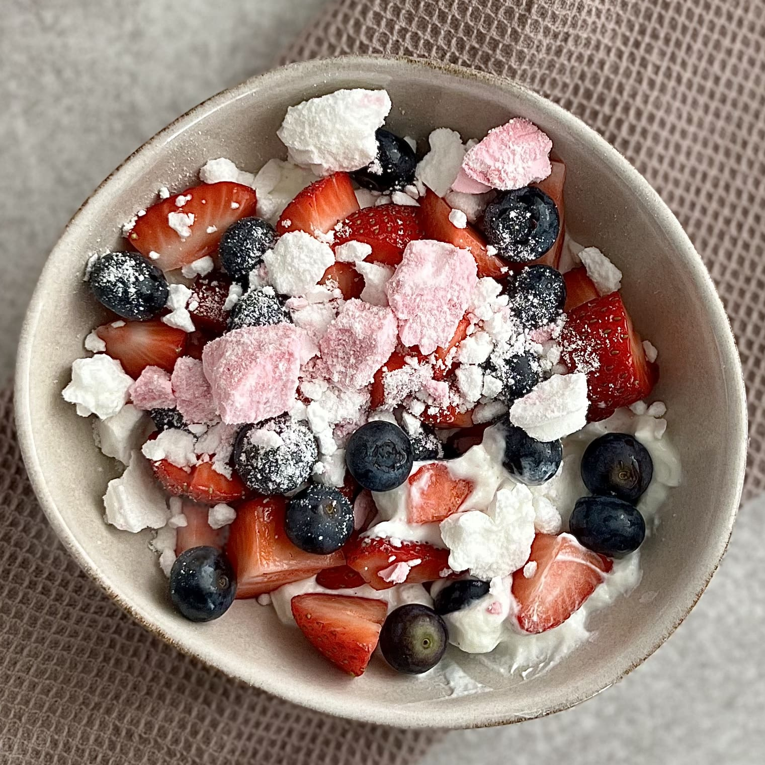 Nærbilde av Elena Mellingen sin oppskrift Pavlova bowl toppet med friske bær og knust marengs fra kostholdsplanen til Elena Mellingen.