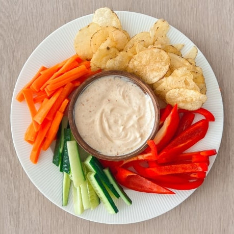 Grønnsaker, dip og chips på hvit tallerken. mellommåltid snack oppskrift fra e-bok.